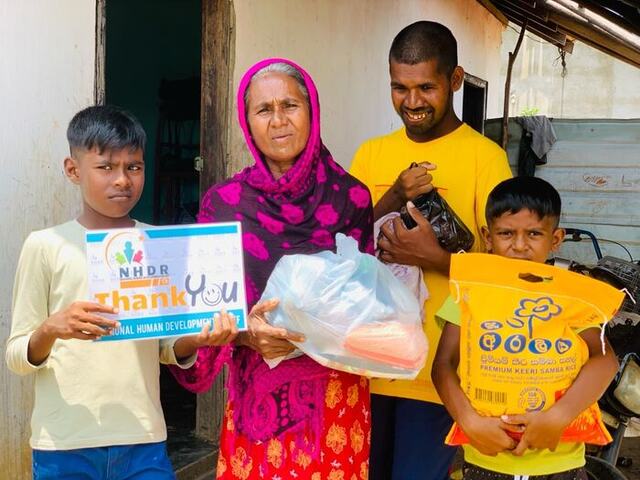 A family of four receiving relief supplies from NHDR